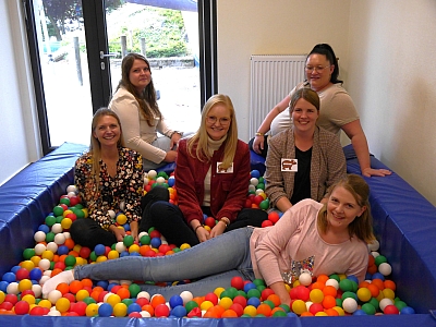 Elternrat St. Marien Schlickelde Eltern sitzen im Bällebad und lachen in die Kamera
